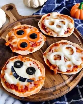 Easy mini Halloween pizzas topped with spooky ingredients for a festive treat