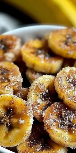 Air fryer cinnamon bananas served in a bowl with a sprinkle of cinnamon.