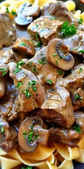 Classic Beef Stroganoff served with egg noodles and garnished with parsley.
