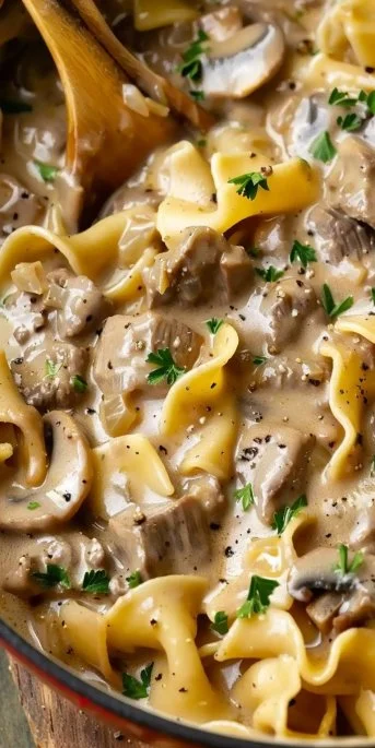 Creamy beef stroganoff served over egg noodles with fresh parsley garnish.