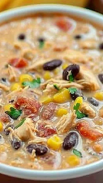 Crock Pot cream cheese chicken chili in a bowl topped with cilantro.