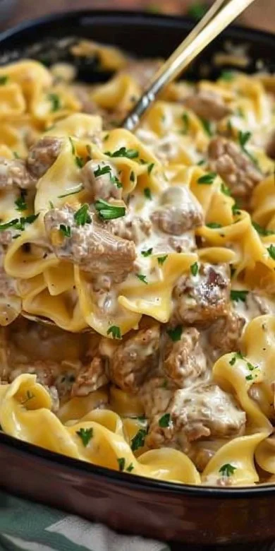Delicious Instant Pot beef stroganoff served in a bowl with noodles and herbs.
