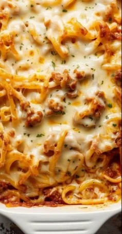 A serving of Million Dollar Spaghetti with cheese and herbs in a bowl.