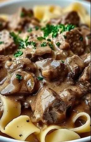 Old fashioned beef stroganoff served with egg noodles and garnished with parsley.