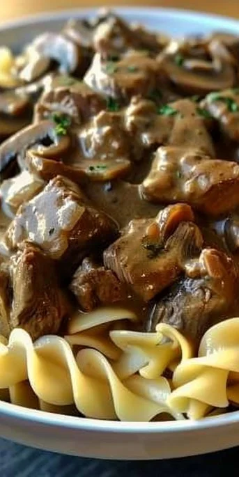 Slow Cooker Beef Stroganoff served in a bowl with creamy sauce and mushrooms