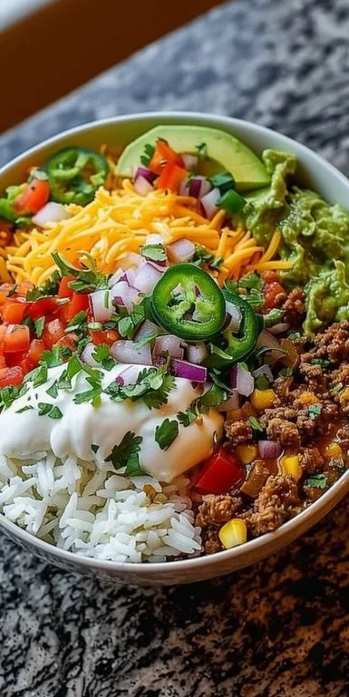 Taco Rice Bowl 3 A colorful Taco Rice Bowl filled with seasoned beef, rice, and fresh toppings.