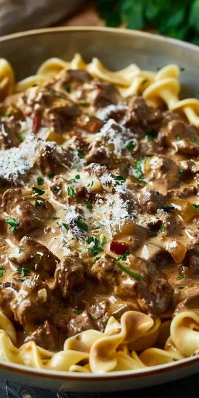 Delicious creamy beef stroganoff served with noodles on a rustic table