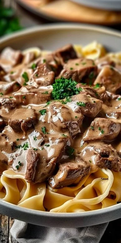 Delicious old fashioned beef stroganoff served with noodles and garnished with parsley.