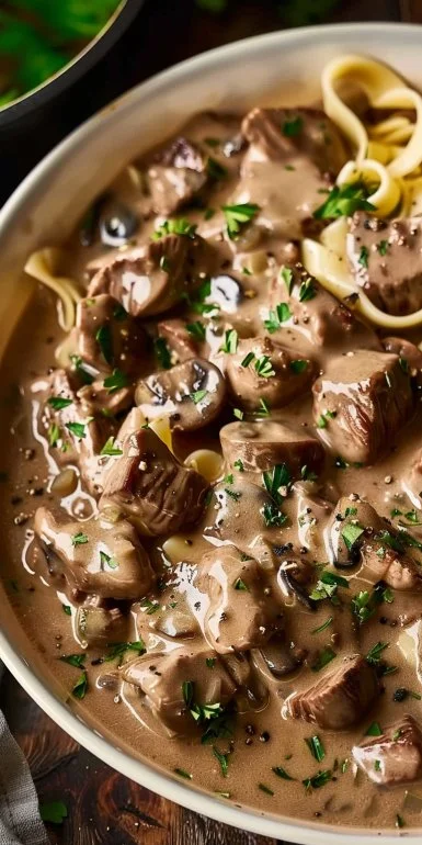 Delicious Beef Stroganoff served on a plate with noodles and garnished with herbs