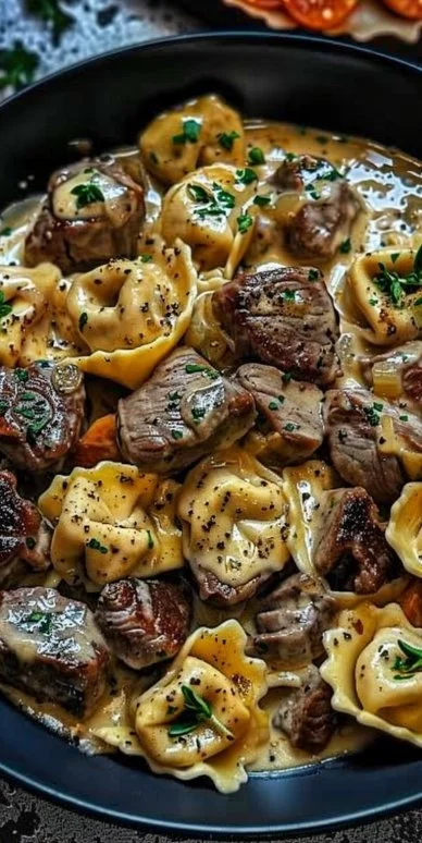 Cracked Garlic Steak Tortellini in creamy sauce served on a plate.