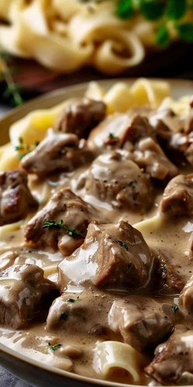 Plate of creamy beef stroganoff with pasta and garnished with parsley