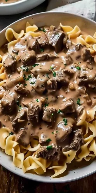 Delicious creamy crockpot beef stroganoff served in a bowl with fresh parsley