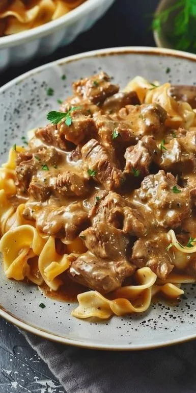 Crockpot Beef Stroganoff 4 Crockpot Beef Stroganoff served in a bowl with noodles and garnished with parsley