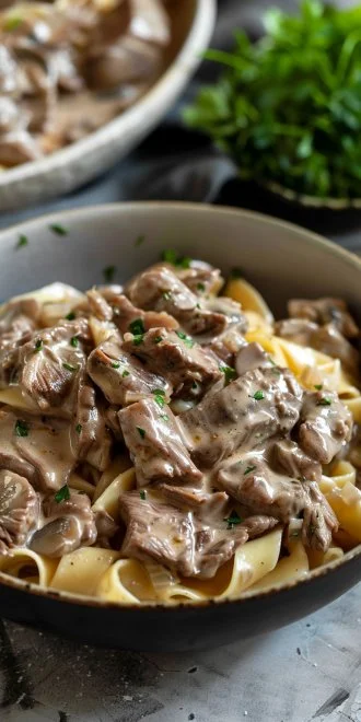 Crockpot Beef Stroganoff served with egg noodles and garnished with parsley