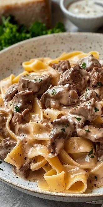 Creamy beef stroganoff pasta served in a bowl, garnished with parsley