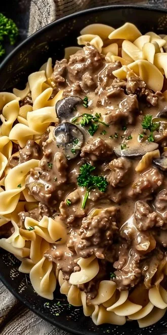 Delicious ground beef stroganoff served with pasta and garnished with parsley