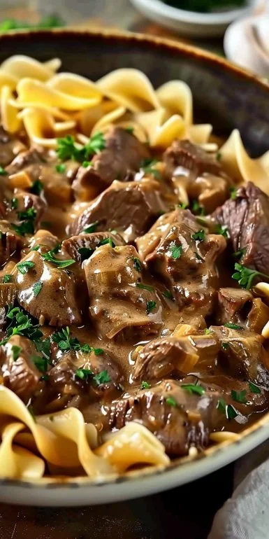 Plate of homemade beef stroganoff with noodles garnished with parsley
