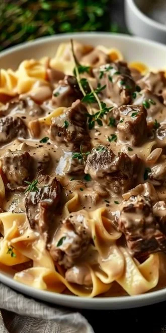 Irresistibly Creamy Beef Stroganoff for Cozy Dinners 4 Creamy beef stroganoff served on a plate with noodles and garnished with parsley.
