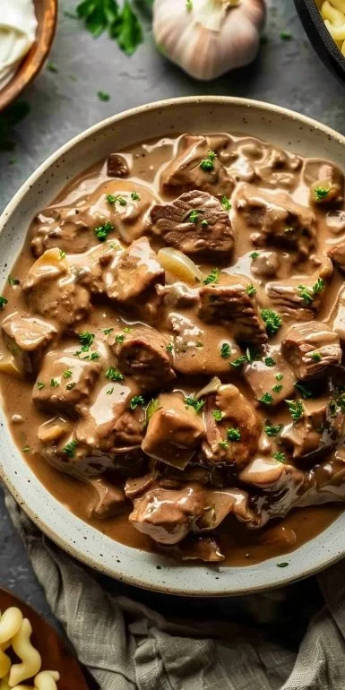 Delicious beef stroganoff served with creamy sour cream over pasta.