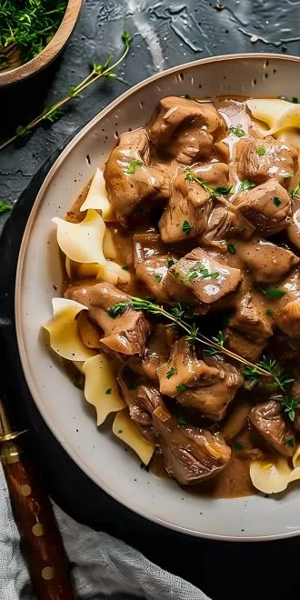 Delicious slow cooker beef stroganoff served with noodles and fresh parsley