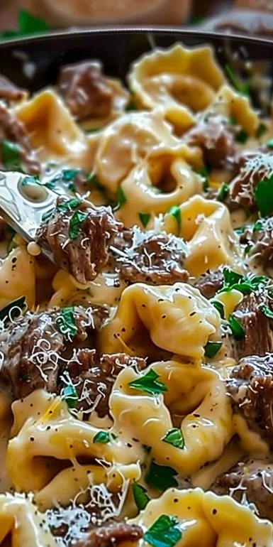 Delicious Cheesesteak Tortellini in creamy provolone cheese sauce served in a bowl
